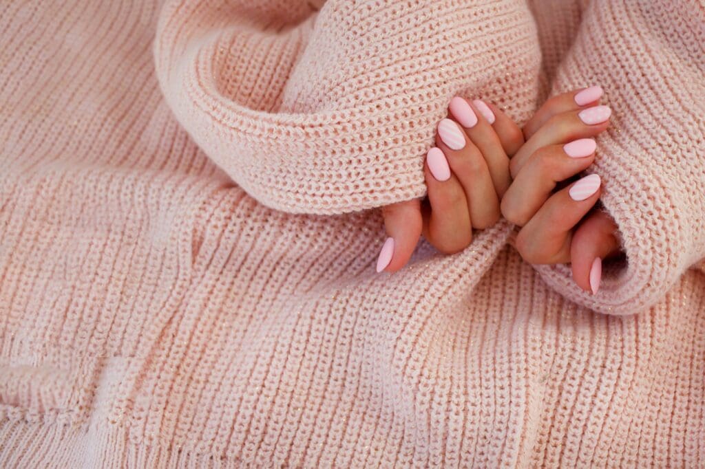 Female hands with beautiful oval-shaped nails, matte pink manicure